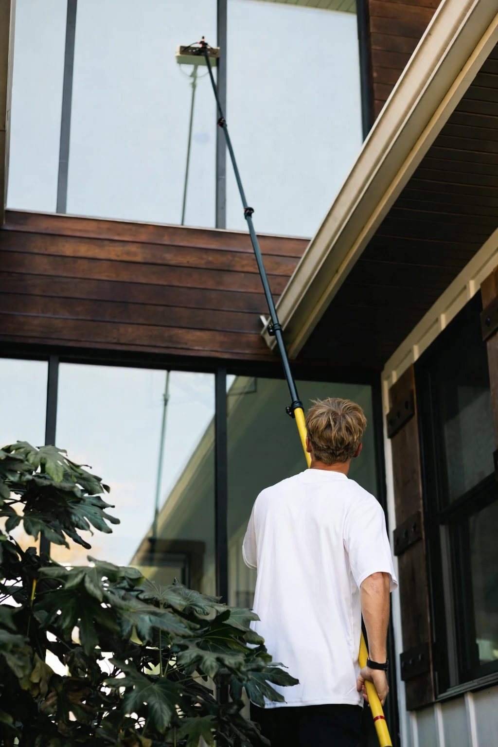 Reeces Window Cleaning technician using water-fed pole on a residential property in Kootenai County